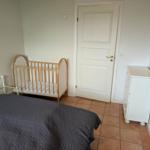 Bedroom with crib, bed, and dresser.