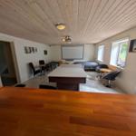Room with ping pong table, bed, seating, and projection screen.