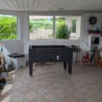 Room with foosball table, childrens toys, and windows to the outside.