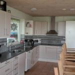 Kitchen with light cabinets, worktop, and kitchen appliances.