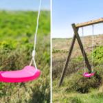 Zwei rosa Schaukeln hängen an einem Holzgestell im Gras.