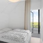 Bedroom with bed and balcony door to field