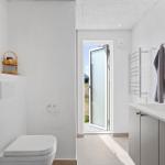 Bathroom with toilet, sink, and door to outdoor area.