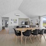 Modern kitchen with dining area and large window view of the landscape.