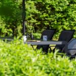 Terrace with table, chairs, and view into the green garden.
