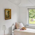 Bedroom with bed, window, lamp, and picture on the wall.