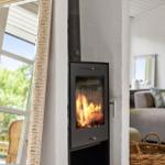 Wood-burning stove with fire in living room with sofa and mirror