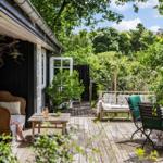 Deck with wooden planks, seating, and green surroundings.