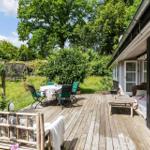 Wooden terrace with table, chairs, and garden view