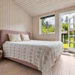 Bedroom with bed, windows, and door to outdoor terrace.