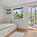 Bedroom with bed, window, and door to terrace.