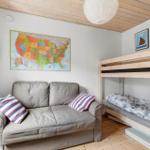 Room with sofa bed, bunk bed, and US map on the wall.