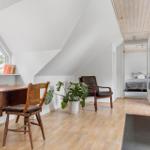 Dachgeschosszimmer mit Schreibtisch, Sessel und Blick auf Schlafzimmer.