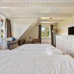 Schlafzimmer mit Doppelbett, TV und Fenster zur Aussicht.