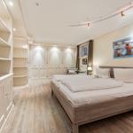 Schlafzimmer mit Doppelbett, Kleiderschrank und Holzboden.