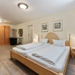 Schlafzimmer mit Doppelbett, Holzmöbel und Kleiderschränken.