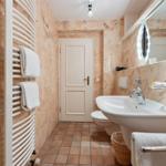 Badezimmer mit Waschbecken, Toilette, Heizung und Spiegel