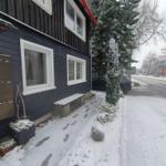 Schneebedeckter Eingangsbereich eines Hauses mit Bank und Briefkasten.