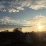 Sonnenuntergang über Dächer und Bäume in einer ruhigen Wohngegend.