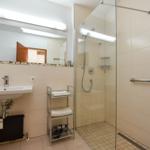Badezimmer mit Dusche, Waschbecken und Spiegel
