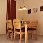 Dining room with wooden table, four chairs, and wall art