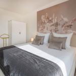 Schlafzimmer mit Bett, Wandbild und Nachttisch