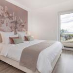 Schlafzimmer mit Bett, Wandbild und Blick auf den Hafen.