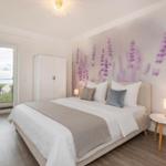 Schlafzimmer mit Bett, Wandtapete und Fensterblick auf Wasser