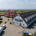 Zwei Gebäude mit Parkplatz und Blick aufs Meer