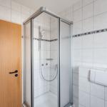 Bad mit Dusche, Toilette und Holztür