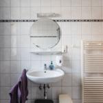 Badezimmer mit Waschbecken, Spiegel und Handtuchhalter