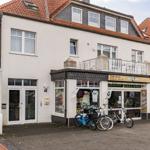 Haus mit Laden und Fahrrädern vorne. Dach mit Schiefer und Dachfenstern.
