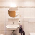 Badezimmer mit Waschbecken, Spiegel und Handtuchhalter