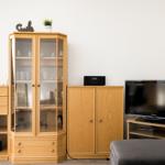 Holzschrank mit Glasfront, Fernseher und Sideboard im Wohnzimmer