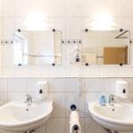 Zwei Waschbecken mit Spiegeln und Handtuchhalter an der Wand.