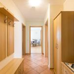 Flur mit Holzgarderobe, Schrank und Blick in Esszimmer.