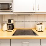 Küche mit Herd, Kaffeemaschine, Toaster und Mikrowelle.