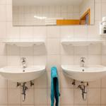 Zwei Waschbecken mit Spiegeln und Handtuchhalter an der Wand.