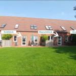 Ferienhaus mit Garten und Blickmöglichkeiten auf Deich, Feld, Marsch und Warf.