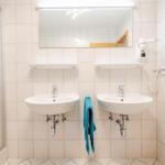 Zwei Waschbecken mit Spiegeln und Handtuchhalter an der Wand