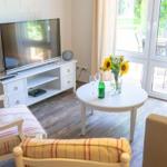 Wohnzimmer mit TV, Couch, Tisch und Blick auf die Terrasse.
