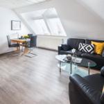Wohn- und Essbereich mit Sofa, Stühlen und Dachfenstern.