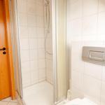 Dusche mit Glaswand, Toilette und grüner Handtuch