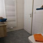 Badezimmer mit Waschbecken, Toilette und Heizkörper