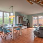 Wohn- und Essbereich mit Holztreppe, Essplatz und Blick auf Garten