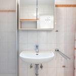 Bad mit Dusche, Waschbecken und Spiegel