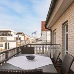Terrasse mit Tisch, Stühlen und Blick auf die Straße.