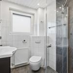 Badezimmer mit Dusche, Toilette und Waschbecken.