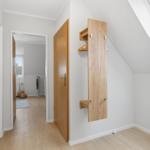 Dachgeschosszimmer mit Holzwandgarderobe und Dachfenster. Durchgang in benachbarte Räume.