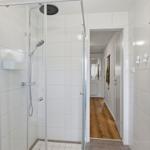 Duschkabine mit Duschbrause und Heizkörper an der Wand